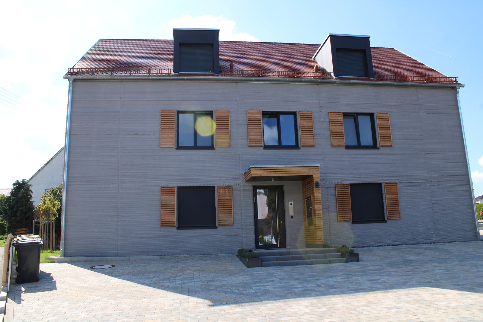 A modern house in Germany with rounded, layered 3D-printed concrete walls