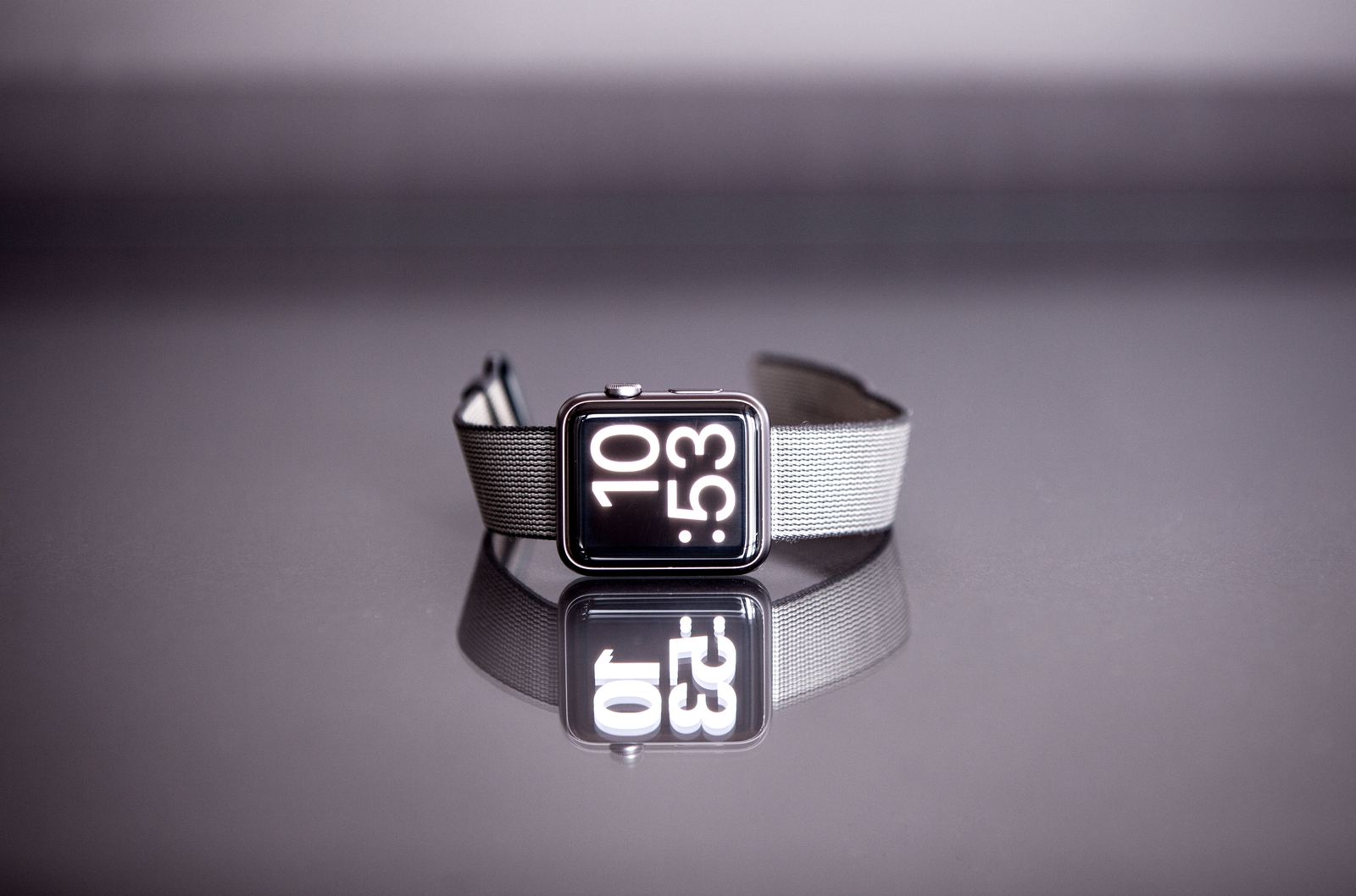 A smartwatch with a dark band lying on its side on a table